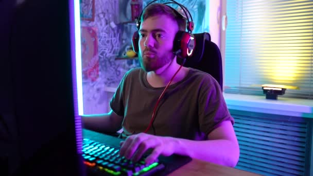 Een jonge gamer speelt emotioneel een computer.. — Stockvideo