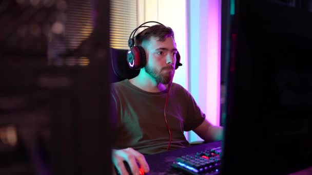 Ein junger Gamer spielt emotional am Computer. — Stockvideo