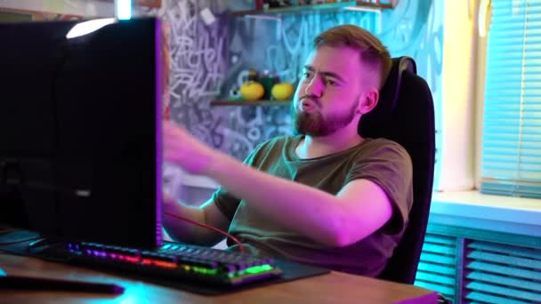 Een jonge gamer speelt emotioneel een computer.. — Stockvideo