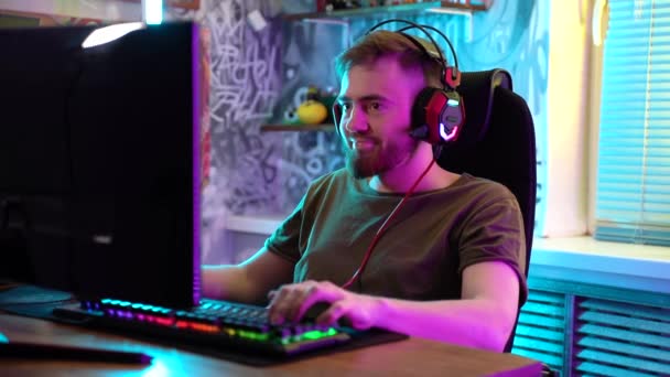 若いゲーマーの男は感情的にコンピュータをプレイしています. — ストック動画