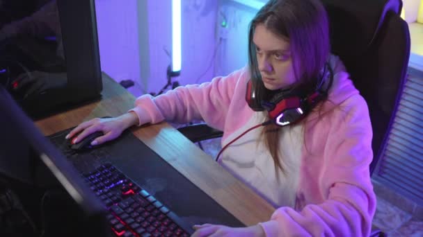 Uma jovem jogadora emocionalmente joga um jogo de computador . — Vídeo de Stock