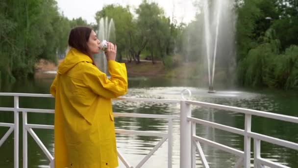 Kız elinde bir bardak kahve tutuyor, dudaklarına getiriyor ve içiyor.. — Stok video