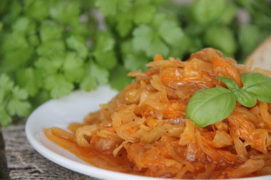 Yuvarlak ahşap bir fincanda taze maydanozlu haşlanmış lahana.