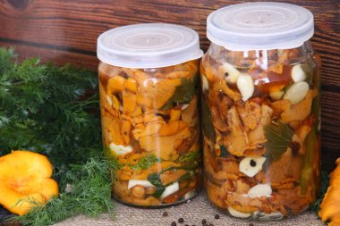 Ahşap bir arka planda 2 kutu tuzlanmış chanterelles.