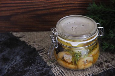 Peçetenin arkasındaki küçük kavanozda tuzlu orman mantarları.