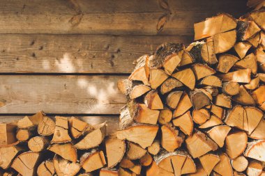 Sıcak kontrastlı bir kır evinde eski kahverengi portakal odun yığını. Metin için boş kopya alanı olan bir fotoğraf.
