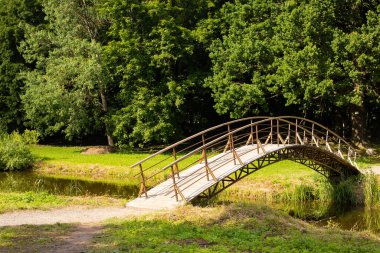 Dukora, Belarus - 18 Temmuz 2020: Dukora Maentak Müzesi Minsk bölgesi. Parkta bir köprü. Güneşli güzel hava, yeşil ağaçlar ve mavi gökyüzü