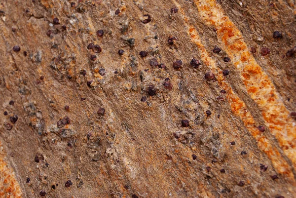 Small druse of crystals garnet stone in the rocks. Surface of mountains with garnets in Pakistan. Stone background