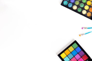 Beyaz yatay arka planda fırçaları olan renkli göz farı paleti. Vizajinalar için çok renkli paletleri olan yatay afiş, boşluğu kopyala.