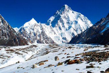 Chogori K2 'nin mavi gökyüzüyle dağların zirveleri. Pakistan Karakorum 'da kış turizmi. At manzarası üzerine kar vadisi.