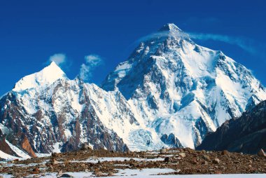 Chogori K2 'nin mavi gökyüzüyle dağların zirveleri. Pakistan Karakorum 'da kış turizmi. At manzarası üzerine kar vadisi.