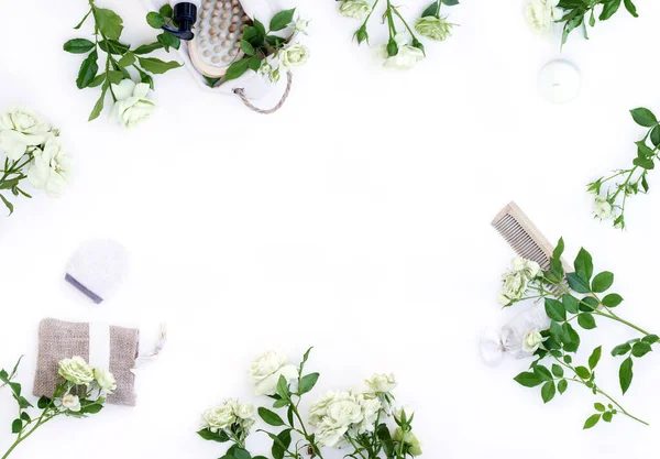 Spa aksesuarları ve beyaz güllü masaj fırçaları. Çiçeklerle sıfır atık düz konsept. Tahta fırça, sünger, tarak ve doğal malzemeden yapılmış el bezi. Üst görünüm, alanı kopyala