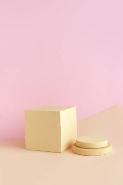 Ürün için pastel arka planda geometrik şekilli soyut boş podyum. Çemberli bej küp açık kahverengi ve pembe arka planda duruyor. Kristal şablonu. Minimum konsept. Model.