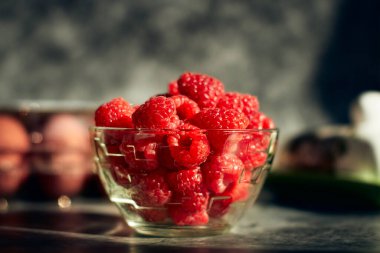 Siyah bir masada olgun kırmızı ahududular.