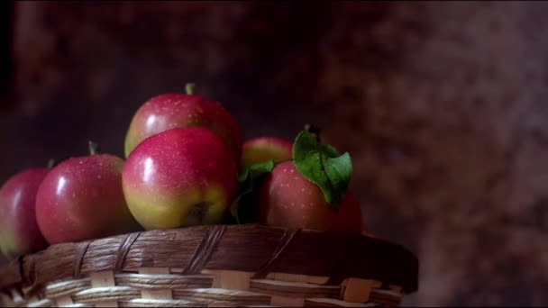 Кошик з стиглими червоними яблуками на дерев'яній лавці — стокове відео