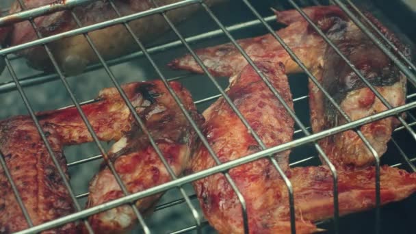 Gegrilde kip. Gegrilde kippenpoten, drumsticks met toevoeging van knoflook, citroen en rozemarijn op grillplaat. Grillvoedsel — Stockvideo