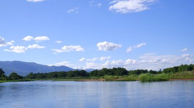 Mavi gökyüzü ve dağdan oluşan bir nehir.