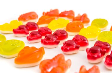 Beyaz arka planda renkli jöle şekerleri. Reçelli şekerlerle donatılmış arka plan.