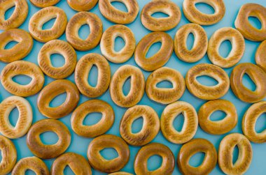 Pek çok lezzetli çöreğin yakın çekimi. Mavi arka planda bir sürü simit. Simit ile arkaplan.