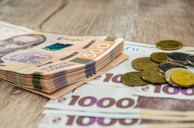 Ahşap zemin üzerinde bozuk paralar olan 1000 ve 500 Hryvnia. Yakın plan. İş konsepti.