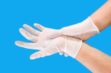 Doktor mavi arka planda izole edilmiş koruyucu mavi eldivenler giyiyor.. 