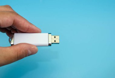 Mavi arka planda beyaz flaş bellek var. Yakın plan. Uzayın kopyası. Metin için yer.