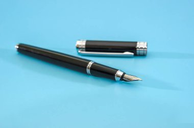 Siyah kalem mavi arka planda izole edilmiş. Boşluğun kopyası.