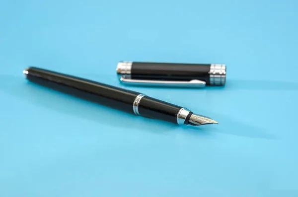 black pen isolated on blue background. Copy of space.