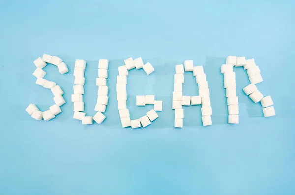 Cubos Açúcar Fundo Azul Isolado Que Compõem Uma Palavra Açúcar — Fotografia de Stock