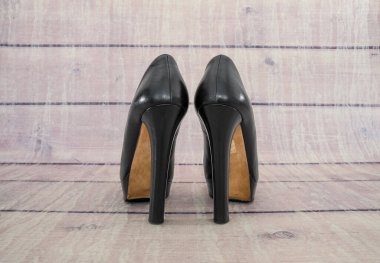 Ahşap arka planda siyah topuklu kadın ayakkabıları. Arka plan.