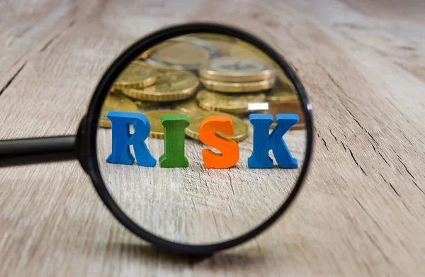 Ordet Risk Läggs Bokstäver Genom Ett Förstoringsglas Mynt Träbakgrund Begreppet — Stockfoto