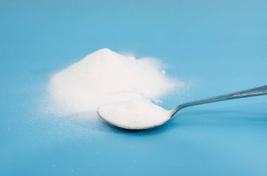 Mavi arka planda kaşıkta beyaz soda..