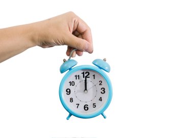 blue alarm clock in a female hand isolated on a white background. Copy of space. Midnight on the alarm clock. clipart