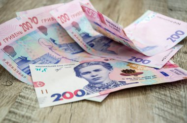 Tahta arka planda 200 Hryvnia banknotundan oluşan yeni banknotlar. Ukrayna parası. İş konsepti.