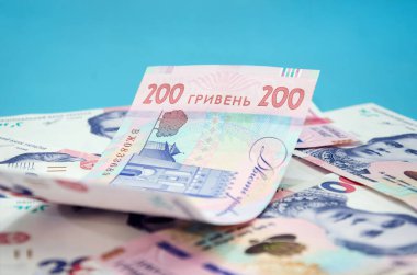 Mavi arka planda 200 hryvnia değerinde yeni banknotlar. Mali konsept.