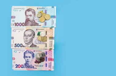 Mavi arka planda yeni Ukrayna banknotları ve sikkeleri. Boşluğun kopyası.