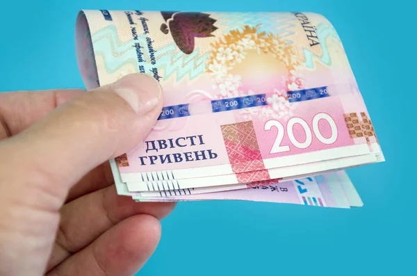 Nieuwe Oekraïense 200 Hryvnia Hand Een Blauwe Achtergrond Close — Stockfoto