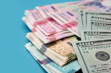Mavi arka planda dolar ve hryvnialar. Çok para. Yakın plan..