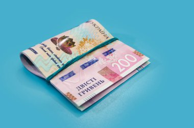 200 Ukrayna Hryvnia banknotundan oluşan bir sürü yeni banknot. Plastikten yapılmış, mavi arka planda izole edilmiş. Avrupa para değişimi. Ukrayna para birimi.