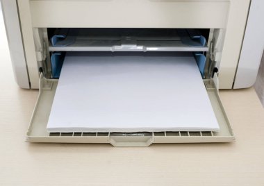 Ofis masasında beyaz kağıt olan gri yazıcı. Yakın plan..
