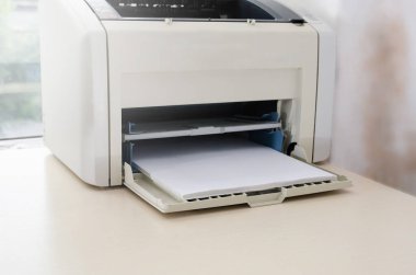 Ofis masasında beyaz kağıt olan gri yazıcı. Yakın plan..