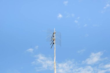 Mavi gökyüzüne karşı TV anteni.