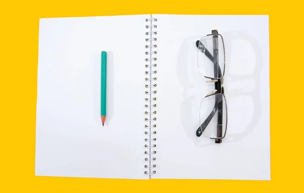 Beyaz Bir Defterine Kalem Gözlük Yukarıdan Bak Sarı Arkaplan — Stok fotoğraf