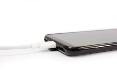 Akıllı telefon için USB kablosu ve beyaz arka planda siyah akıllı telefon. Yakın plan. Telefonunu şarj et..