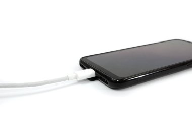 Akıllı telefon için USB kablosu ve beyaz arka planda siyah akıllı telefon. Yakın plan. Telefonunu şarj et..
