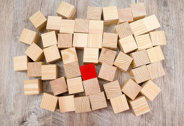 Ortasında kırmızı bir blok olan renksiz ahşap küplerin piramidi. İş tasarımı için yaratıcı şablon