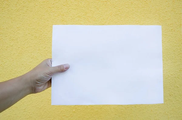Prázdný Bílý List Papíru Ženské Ruce Žlutém Pozadí — Stock fotografie