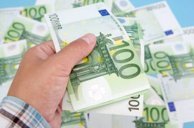 100 avroluk bir kadın eli, paranın arka planına karşı. İş konsepti. Yakın plan..