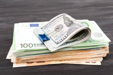 Dolar ve bir yığın avro. Finansal konsept. Koyu ahşap arka planda çok para var.