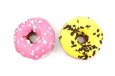 Pembe ve sarı jöleli iki tatlı çörek ve beyaz arka planda çikolata parçacıkları. Yukarıdan görüntüle.